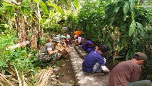 Karya Bhakti Babinsa Bersama Warga Pasang Paving Jalan Desa