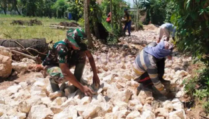 Satgas TMMD bersama warga menata batu untuk perbaikan jalan poros Desa Tanjung, Kecamatan Saronggi, Kabupaten Sumenep.