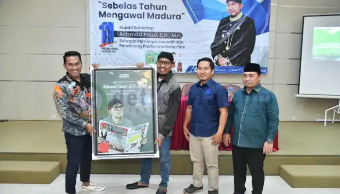 Bupati Sumenep, Achmad Fauzi (pakai blangkon) menerima penghargaan dari Direktur koran Kabar Madura, Fathor Rahman (kiri).