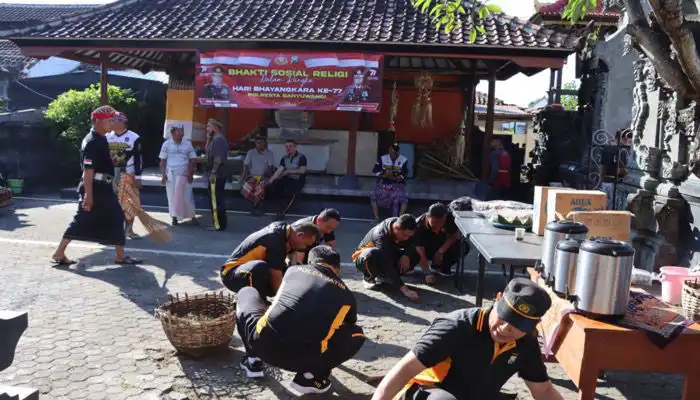 Personel Polresta Banyuwangi sadang melakukan bersih-bersih di lingkungan Pure Girinata.