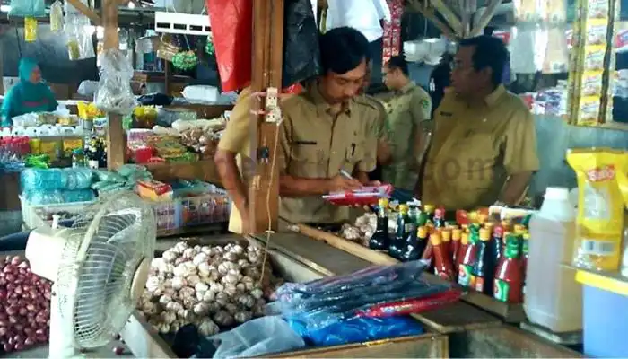 Petugas sedang mengecek harga sembako dan komoditas lainnya di Pasar Anom Baru Sumenep.