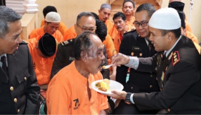 Kapolres Sumenep, AKBP Edo Satya Kentriko menyuapi seorang tahanan dengan nasi tumpeng HUT ke-77 Bhayangkara.