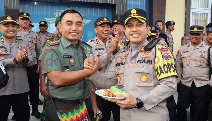Dandim 0827/ Sumenep, Letkol Czi Donny Pramudya Mahardi memberikan potongan tumpeng pertama kepada Kapolres Sumenep, AKBP Edo Satya Kentriko.