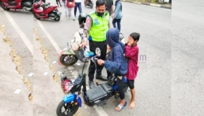 Petugas mengedukasi pengguna sepeda listrik di jalan raya.