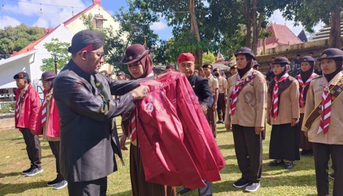 Bupati Sumenep, H. Achmad Fauzi Wongsojudo memakaikan seragam sebagai tanda pelepasan kontingen Pramuka ke Korea Selatan.