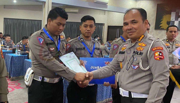 Anggota Satlantas Polres Sumenep, Briptu Robert (kiri) menerima penghargaan juara 2 dari Dirgakkum Korlantas Polri Kombes Pol Hotman Sirait (kanan).