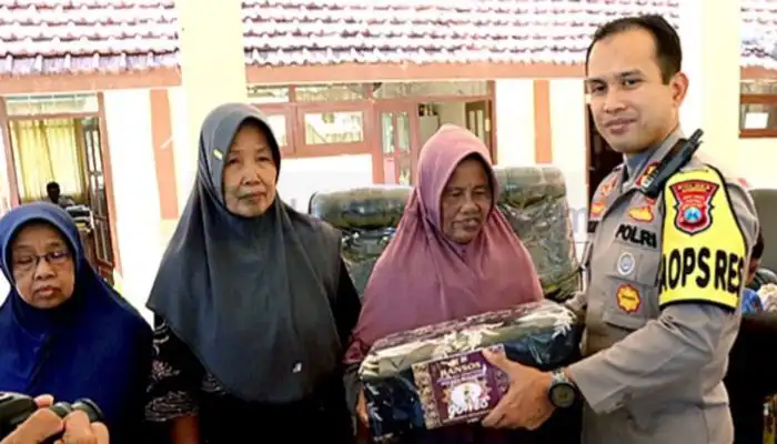 Kapolres Sumenep, AKBP Edo Satya Kentriko menyerahkan bantuan kepada warga saat acara Jumat Curhat di Kecamatan Talango.