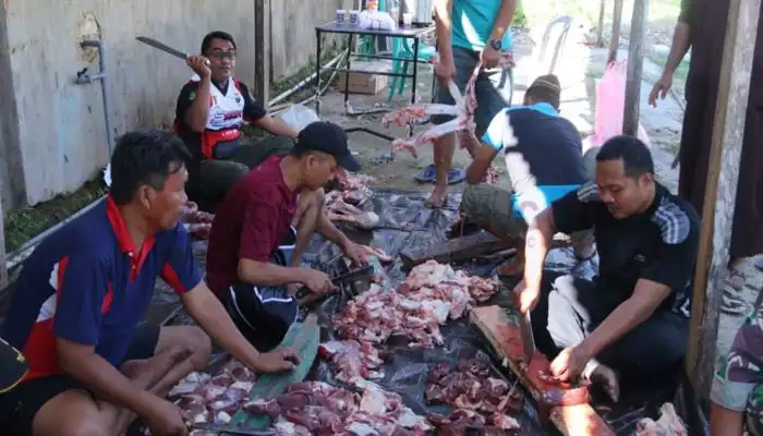 Warga menyembelih hewan kurban untuk dibagikan dagingnya kepada masyarakat.