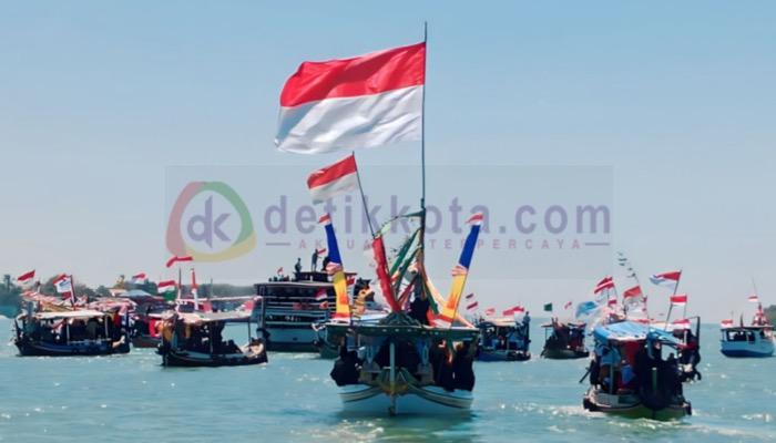 Konvoi kapal tongkang dan perahu dihiasi bendera merah putih menuju lokasi ucapara HUT ke-78 Kemerdekaan RI di Dermaga Pulau Poteran.