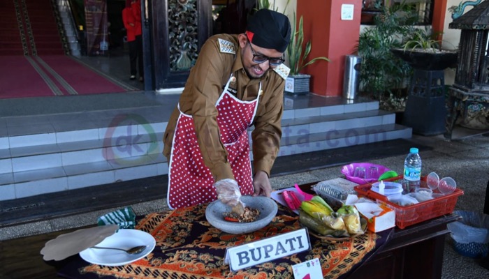 Bupati Sumenep, H. Achmad Fauzi Wongsojudo mengulek rujak dalam lomba 'ngochek rojek' di depan Kantor Bupati setempat.