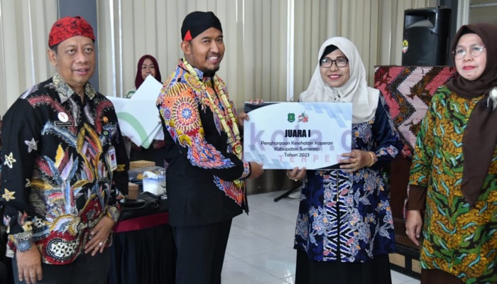 Bupati Sumenep, H. Achmad Fauzi Wongsojudo didampingi Kepala Diskop UKM Perindag, Chainur Rasyid menyerahkan Penghargaan Koperasi Sehat.
