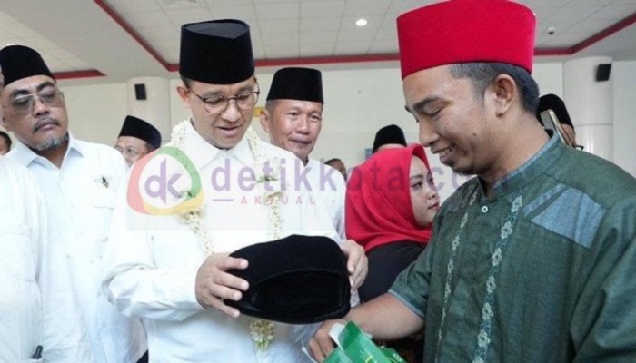 Anies Baswedan menerima hadiah songkok dari Habibullah Salim di Bandara Trunojoyo Sumenep.