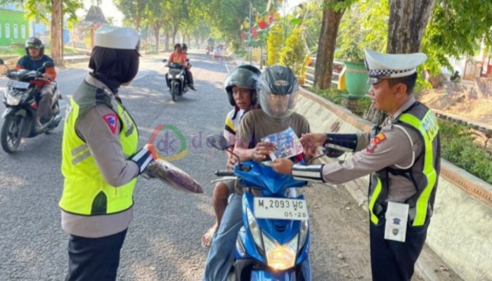 Anggota Satlantas Polres Sumenep memberikan hadiah pada pengendara yang taat aturan.