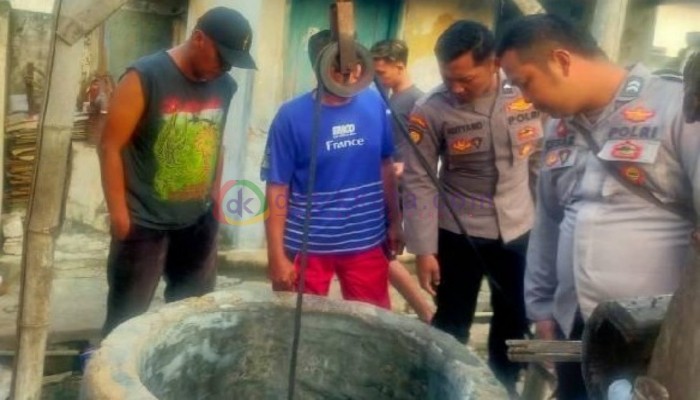 Petugas kepolisian bersama warga mengevakuasi korban dari dalam sumur.