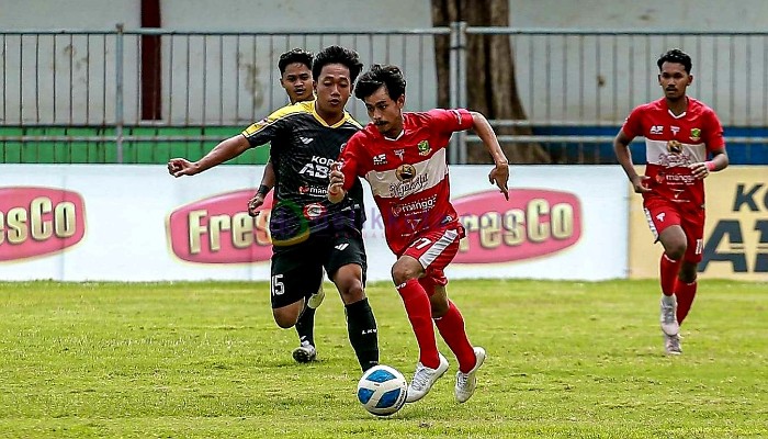 Pemain Perssu Madura City, Saugi menggiring bola dibayang-bayangi pemain Mitra Baruna Utama di Stadion Untung Suropati, Pasuruan.