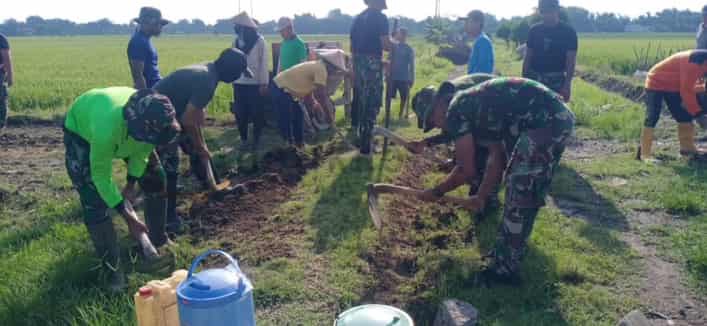 Anggota TNI Bersama Masyarakat Membangun Jalan
