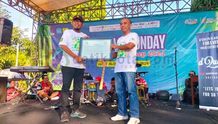 Bupati Fauzi saat menerima sertifikat REC dari Manajer PLN UP3 Pamekasan Fahmi Fahresi.