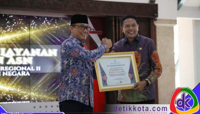 Kepala BKN Zudan Arif Fakrulloh (kiri) menyerahkan piagam penghargaan kepada Wali Kota Malang Wahyu Hidayat.