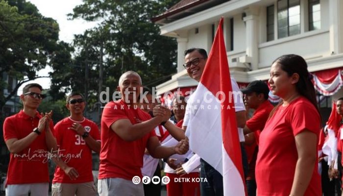 Sekda Kota Malang Erik Setyo Santoso (kiri) secara simbolis menyerahkan bendera Merah Putih kepada Camat Klojen, Willstar Taripar Hatoguan (kanan).
