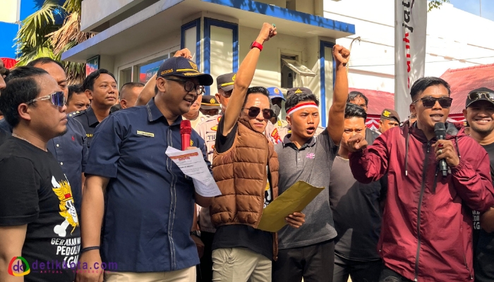 Didik Haryanto (memakai kacata hitam dengan tangan terkepal) dan Kepala Bea Cukai Madura, Novian Dermawan (memakai topi hitam).