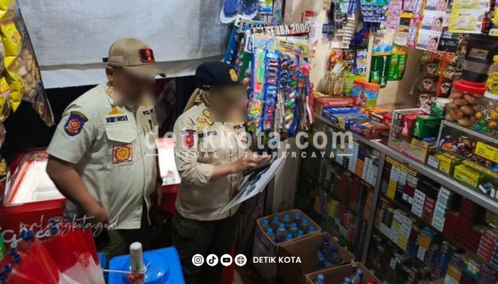 Petugas Satpol PP Kota Malang saat memeriksa salah satu toko.