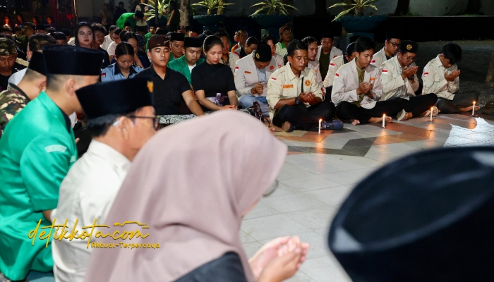 Pemuda lintas agama menyalakan lilin dalam doa bersama di Taman Makam Pahlawan Wisma Raga Satria Banyuwangi, Selasa (2/9/2025) malam.