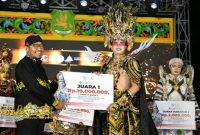 Bupati Sumenep Achmad Fauzi Wongsojudo saat memberikan kepada juara Madura Ethnic Carnival (MEC) 2025 di depan Labang Mesem Keraton Sumenep, Sabtu (20/9/2025).