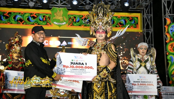 Bupati Sumenep Achmad Fauzi Wongsojudo saat memberikan kepada juara Madura Ethnic Carnival (MEC) 2025 di depan Labang Mesem Keraton Sumenep, Sabtu (20/9/2025).