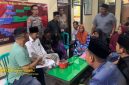 Petugas Polsek Lenteng saat memfasilitasi musyawarah penyelesaian kasus di Balai Desa Ellak Daya, Sumenep.