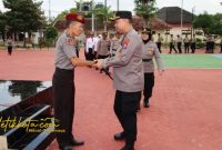 Kapolres Sumenep AKBP Rivanda, S.I.K. menyerahkan ucapan selamat kepada personel yang memperoleh kenaikan pangkat pengabdian dalam upacara di Mapolres Sumenep, Senin (29/9/2025).