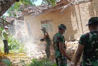 Anggota Koramil 0827/20 Sapudi bersama warga bergotong royong membersihkan puing rumah warga terdampak gempa di Desa Pancor, Kecamatan Gayam, Pulau Sapudi, Ahad (5/10/2025).