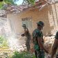 Anggota Koramil 0827/20 Sapudi bersama warga bergotong royong membersihkan puing rumah warga terdampak gempa di Desa Pancor, Kecamatan Gayam, Pulau Sapudi, Ahad (5/10/2025).