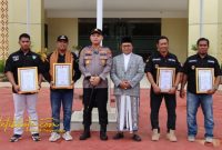 Kapolres Sumenep AKBP Rivanda, S.I.K. menyerahkan piagam penghargaan kepada warga yang berperan aktif membantu tugas kepolisian, Senin (20/10/2025).