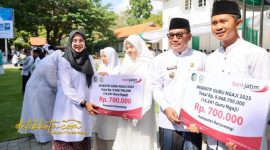 Bupati Banyuwangi Ipuk Fiestiandani menyerahkan insentif kepada perwakilan guru ngaji saat upacara peringatan Hari Santri Nasional 2025 di halaman Kantor Bupati Banyuwangi.