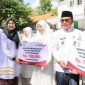 Bupati Banyuwangi Ipuk Fiestiandani menyerahkan insentif kepada perwakilan guru ngaji saat upacara peringatan Hari Santri Nasional 2025 di halaman Kantor Bupati Banyuwangi.
