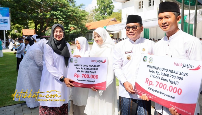 Bupati Banyuwangi Ipuk Fiestiandani menyerahkan insentif kepada perwakilan guru ngaji saat upacara peringatan Hari Santri Nasional 2025 di halaman Kantor Bupati Banyuwangi.