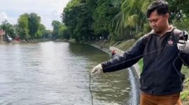 Petugas Dinas Lingkungan Hidup (DLH) Kota Surabaya saat mengambil sampel air di saluran Banyu Urip untuk uji kualitas air.