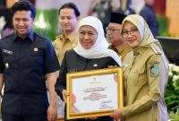Bupati Banyuwangi Ipuk Fiestiandani menerima penghargaan Kepala Daerah Terbaik III Pembina Siskamling Terpadu Merah Putih Jogo Jawa Timur 2025 dari Gubernur Khofifah Indar Parawansa di Surabaya, Selasa (4/11/2025).
