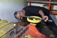 Sucipto memeriksa turbin PLTMH buatannya di aliran sungai Dusun Kajar Kuning, Desa Sumberwuluh, Lumajang.