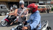 Personel Satlantas Polres Sumenep memberikan edukasi keselamatan berlalu lintas dan membagikan brosur Operasi Zebra 2025 kepada pengunjung Pasar Tumpah Prenduan, Rabu (19/11/2025).