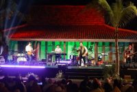 Suasana konser Seamphony Banyuwangi di Pantai Villa Solong dengan penonton menikmati musik di hamparan rumput tepi pantai.