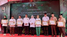 Gubernur Jawa Timur Khofifah Indar Parawansa didampingi Bupati Lumajang Indah Amperawati menyerahkan bantuan alat pengolahan gula kelapa dan bibit pohon kelapa kepada warga terdampak erupsi Gunung Semeru di Kabupaten Lumajang, Jumat (12/12/2025).