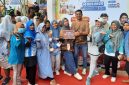 Ketua Posyandu ILP 6 SPM Desa Pinggirpapas Siti Aisyah foto bersama usai menerima piala Juara I Posyandu Integrasi Layanan Primer tingkat Kabupaten Sumenep pada ajang Sumenep Fun Run 2025.