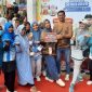 Ketua Posyandu ILP 6 SPM Desa Pinggirpapas Siti Aisyah foto bersama usai menerima piala Juara I Posyandu Integrasi Layanan Primer tingkat Kabupaten Sumenep pada ajang Sumenep Fun Run 2025.