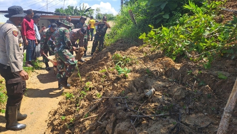 Personel Polsek Guluk-Guluk bersama TNI dan warga melakukan kerja bakti membersihkan material longsor di Dusun Artakoh, Desa Payudan Daleman, Kecamatan Guluk-Guluk.