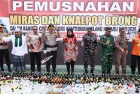 Bupati Banyuwangi Ipuk Fiestiandani bersama Kapolresta Banyuwangi Kombes Pol Rama Samtama Putra saat memusnahkan barang bukti hasil operasi cipta kondisi kamtibmas jelang Nataru, berupa 5.222 liter minuman keras serta puluhan knalpot brong.