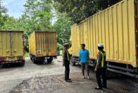 Petugas Satlantas Polres Sumenep memberikan imbauan keselamatan berlalu lintas kepada sopir truk terkait over dimensi dan over muatan dalam kegiatan Polantas Menyapa di area parkir TSI Sumenep, Senin (22/12/2025).