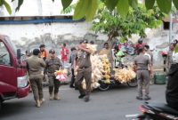 Petugas Satpol PP Kota Probolinggo saat menertibkan pedagang yang berjualan di trotoar Pasar Baru, Senin (05/01/2026).
