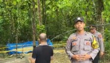 Petugas kepolisian memasang garis polisi di lokasi sumur bor yang mengeluarkan gas di Desa Planggaran Timur, Kecamatan Banyuates, Kabupaten Sampang.