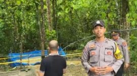 Petugas kepolisian memasang garis polisi di lokasi sumur bor yang mengeluarkan gas di Desa Planggaran Timur, Kecamatan Banyuates, Kabupaten Sampang.